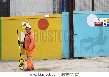 London, Uk - December 22, 2018 Builders At The Colorful Fence Near Tottenham Court Station