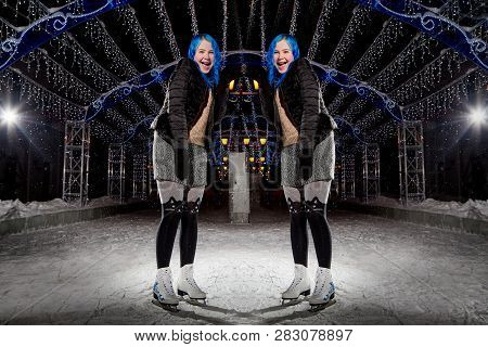 Two Identical Girls With Blut Hair Skating On The Ice Arena In The Evening City Square In Winter