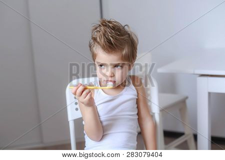 Boy Cleans His Teeth In The Morning And Plays With A Toothbrush.