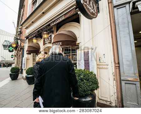 Strasbourg, France - Dec 29, 2018: Couple Entering Reading Menu Of The Brasserie Max In Place De Lho