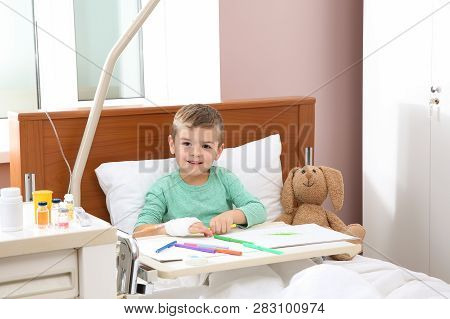 Little Child With Intravenous Drip Drawing In Hospital Bed