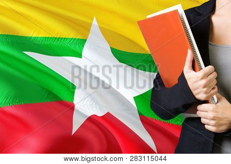 Learning Burmese Language Concept. Young Woman Standing With The Myanmar Flag In The Background. Tea