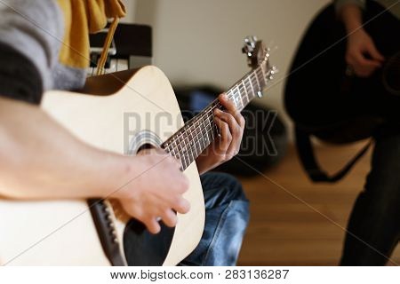The Young Man Is A Soloist On An Acoustic Guitar, Playing With A Friend