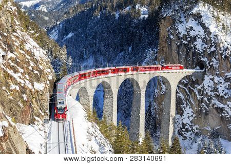 Filisur, Switzerland - January 19. 2019: A Red Passenger Swiss Train Passing On The Landwasser Viadu