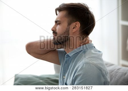 Upset Tired Young Man Feeling Pain Massaging Stiff Neck