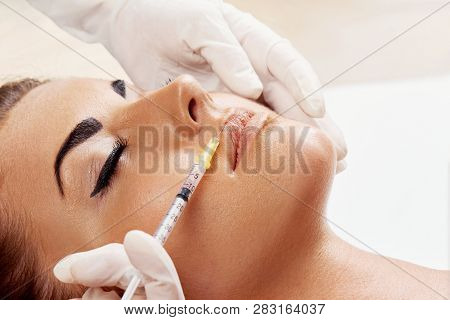 Woman Getting Cosmetic Injection Of Botox In Lips, Closeup. Girl In Beauty Salon. Plastic Surgery Cl
