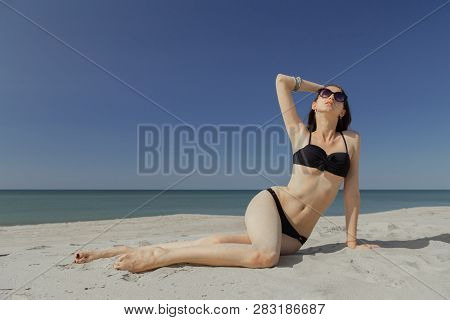 Beautiful Young Woman In Swimsuit At Sand Sea Beach Looking At Camera, Toned Image