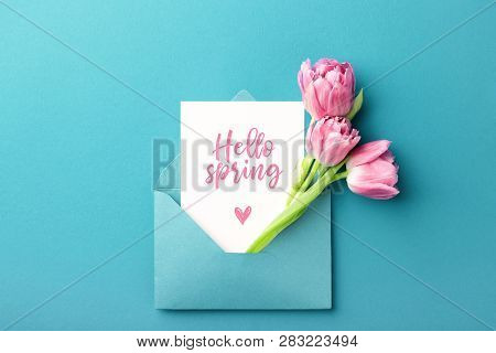 Three Pink Tulips In Turquoise Envelope On Turquoise Background With Inscription Hello Spring. Mocku