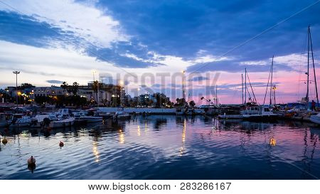 View Of Corinth Port With Boats And Piers Shot At Blue And Pink Dusk