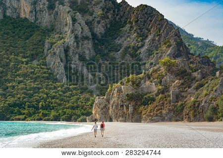 People Walking By The Cirali Beach To Olympos Mountain. Kemer, Antalya, Mediterranean Region, Turkey