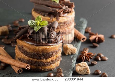 Dark Chocolate Cakes On Black Slattern Board With Mint, Cinnamon, Coffee Beans On A Wooden  Backgrou