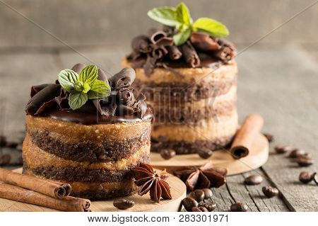 Dark Chocolate Cakes On Black Slattern Board With Mint, Cinnamon, Coffee Beans On A Wooden  Backgrou
