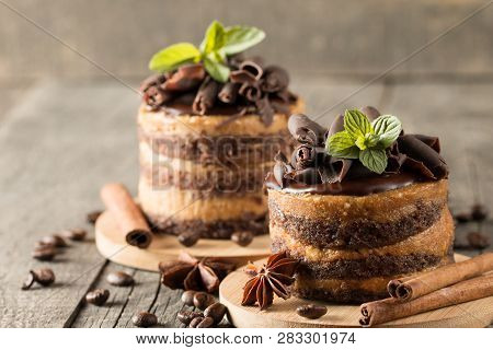 Dark Chocolate Cakes On Black Slattern Board With Mint, Cinnamon, Coffee Beans On A Wooden  Backgrou