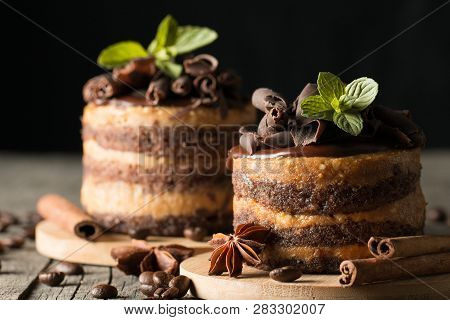 Dark Chocolate Cakes On Black Slattern Board With Mint, Cinnamon, Coffee Beans On A Wooden  Backgrou