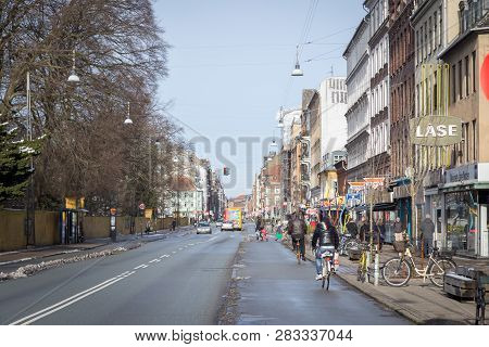 Copenhagen, Denmark - February 25, 2017: Bicycles, People And Cars On Norrebrogade. Norrebrogade Is 