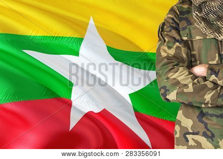 Crossed Arms Burmese Soldier With National Waving Flag On Background - Burma Military Theme.