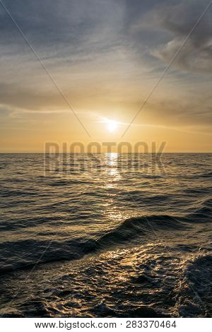 Waves And Foam Astern Of The Yacht. The Setting Sun Is Beautifully Reflected In The Water. Backgroun