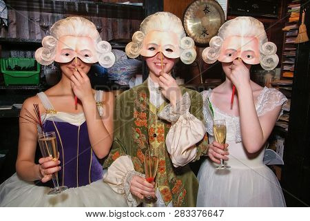 Moscow, Russia - April 2, 2006: Three Smiling Girls In Medieval Costumes And Masquerade Masks Are Ma
