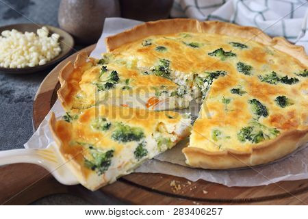 French Cuisine, Crab Sticks Quiche With Broccoli  And Grated Cheese On Wooden Cutting Board