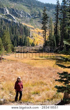 Blonde Female Middle Aged Hiker Poses At Sotcher Lake In The Autumn With Fall Colors On The Tree Lea