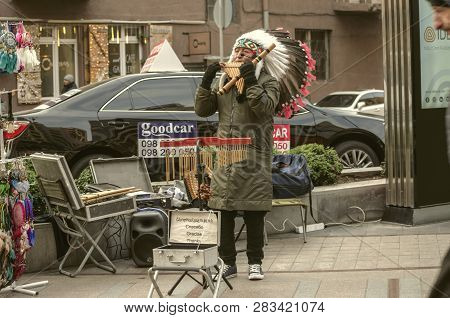 Yerevan,armenia,december 03,2018:on Yerevan Street, A Middle-aged Man In A Feather Headdress Plays A
