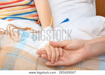 Doctor Holding Little Child's Hand With Intravenous Drip In Hospital, Closeup