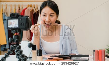 Beauty Blogger Present Beauty Cosmetics Sitting In Front Camera For Recording Video. Beautiful Asian