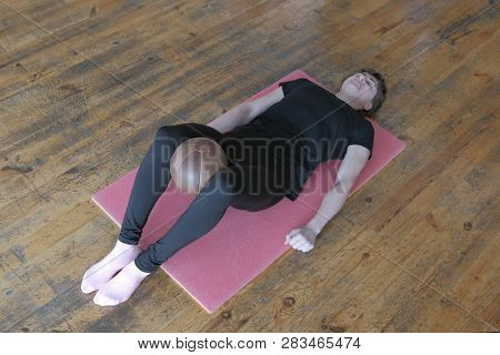 Healthy Lifestyle Concept. A Woman In A Black T-shirt Performs A Fitness Exercise On Stretching The 