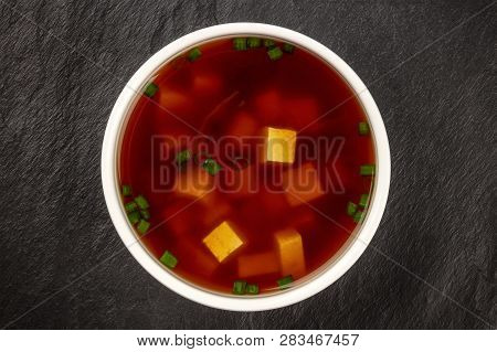 Miso Shiru Soup With Tofu And Scallions, Shot From Above On A Black Background