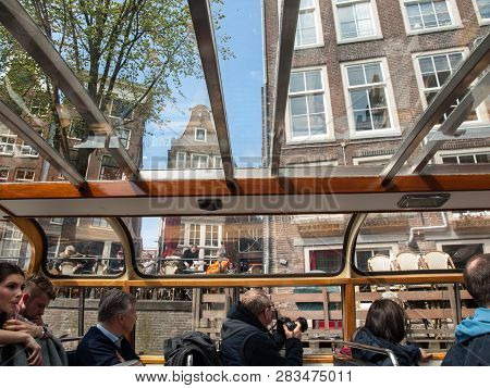 Amsterdam, Netherlands - April 20, 2017:a Tourboat Is Taking Tourists Around The Canals In Amsterdam