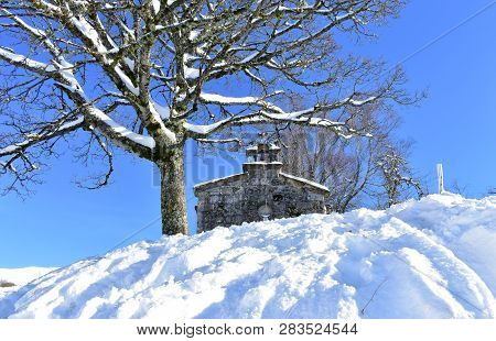 Piornedo, Ancares, Lugo Province, Galicia, Spain. San Lorenzo Hermitage With Snow And Snowy Tree. Su