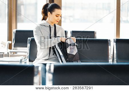 Young Beautiful Girl Looking For Something And Rummaging In Backpack.