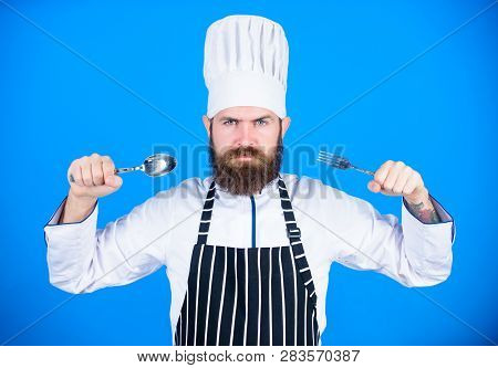 Hungry Chef Ready To Try Food. Time To Try Taste. Chef Serious Strict Face Hold Spoon And Fork. Man 