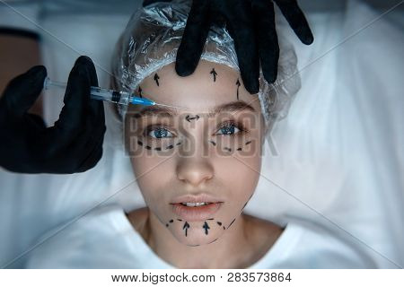 Calm Peaceful Nice Young Woman Lying On Couch And Look Straight. Her Skin Is Marked. Beautician Hold