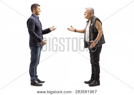 Full length profile shot of a young man having a conversation with an angry mature male punker isolated on white background