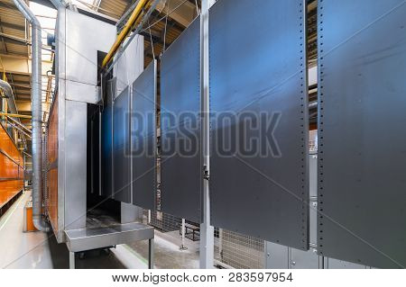 Powder Coating Line. Metal Panels Are Suspended On An Overhead Conveyor Line. Painting Products In A
