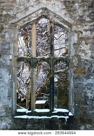 View Through A Window Of A Medieval Ruined Church In Heptonstall Yorkshire With Snow Covered Trees B