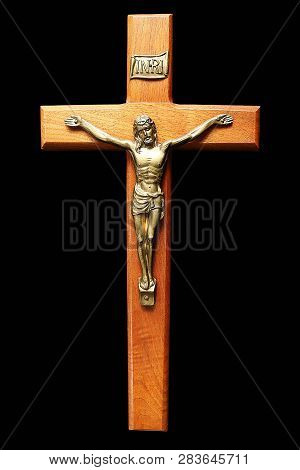 Close-up Of Wooden Crucifix With Gold Body Of Christ Isolated On Black. Concept That Jesus Died In O