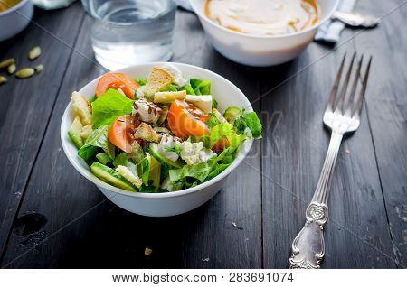 Fresh Light Green Salad With Cucumber, Lettuce, Avocado, Tomatoes, Cheeseand Sseeds And Glass Water 