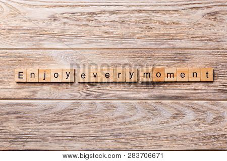 Enjoy Every Moment Word Written On Wood Block. Enjoy Every Moment Text On Wooden Table For Your Desi