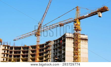 Two Tower Cranes Near Building. Construction Site. Building Under Construction.