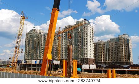 Construction Site Background. Hoisting Cranes And New Multi-storey Buildings. I.ndustrial Background