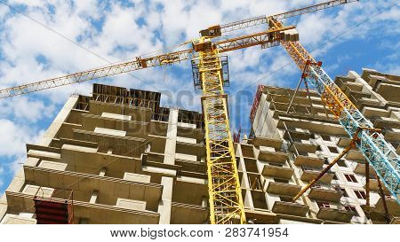 Construction Site Background. Huge Cranes Near Building. Concrete Builsing Under Construction.