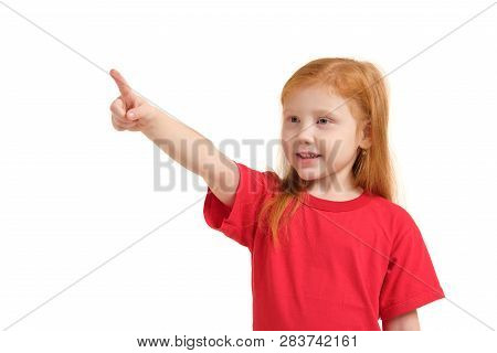 Education, School And Imaginary Screen Concept - Cute Little Girl Pointing In The Air Or Imaginary S