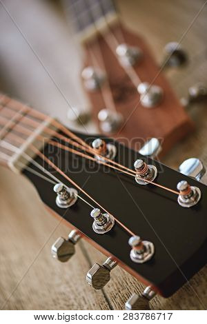 Uppermost Part Of The Guitar. Vertical Close Up Photo Of Guitar Necks With Tuning Keys For Adjusting