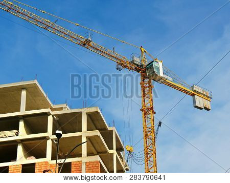 Construction Crane Near The Building Under Construction. Close Up Of A Construction Crane. Self-erec