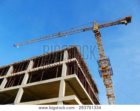 Crane And Concrete Building Under Construction. Construction Site Background