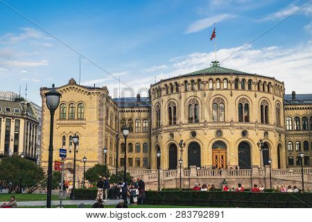 Oslo, Norway - August 3, 2018: People Walk And Relax In The Park Next To The Building Of The Norwegi