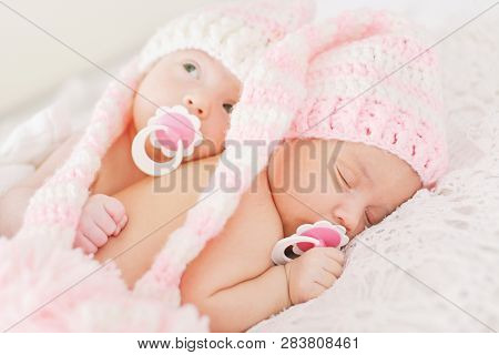 Two Sweet Twins Are Laying On The Bed