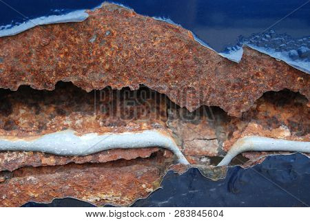 Oxidized Vehicle Damage Showing Peeling Paint And Uncovered Bondo From A Previous Repair.